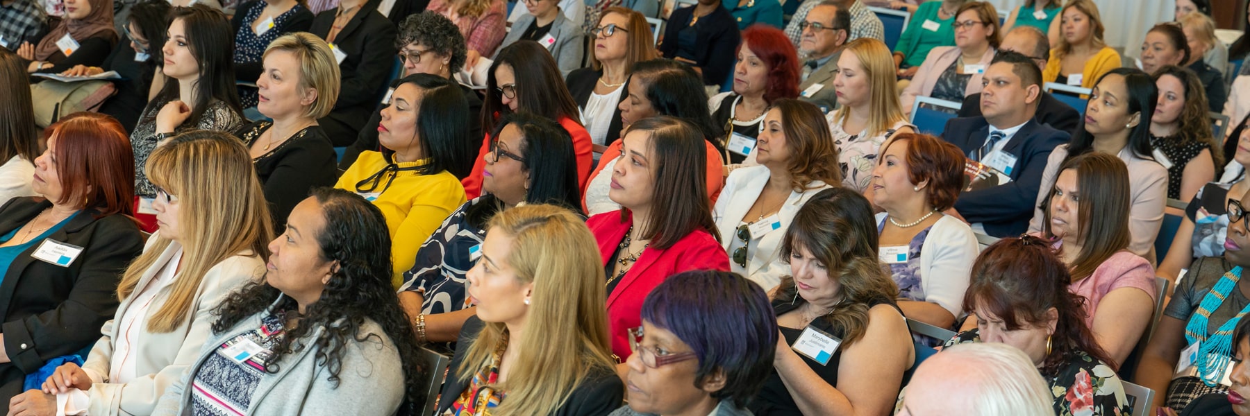 diverse audience in age, gender and ethnicity sitting at a conference