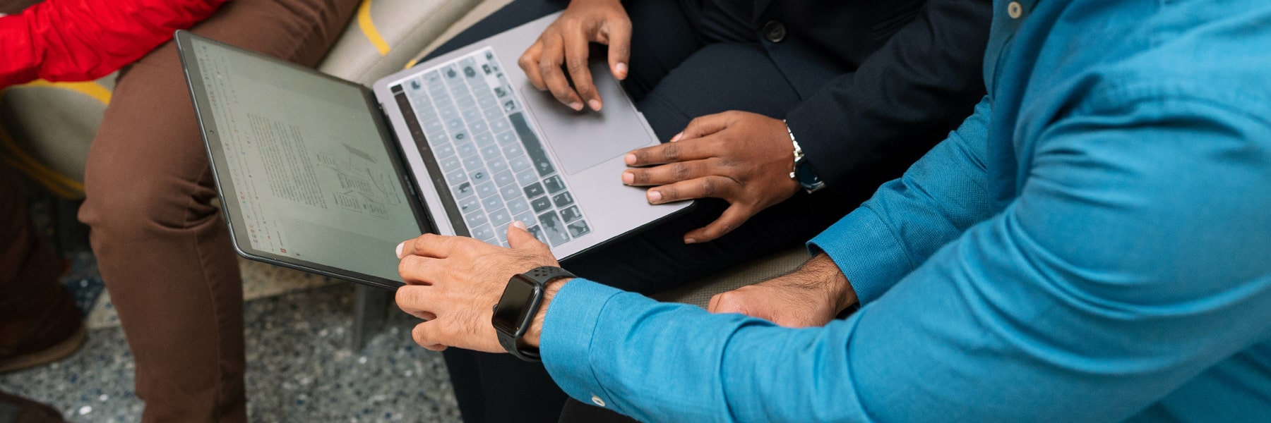 close up of hands on keyboard of laptop resting on someones lap