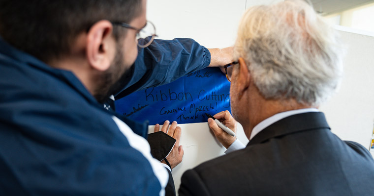 Chancellor signs the ribbon