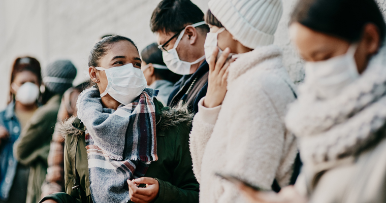 People wearing masks in a crowd in an urban setting 