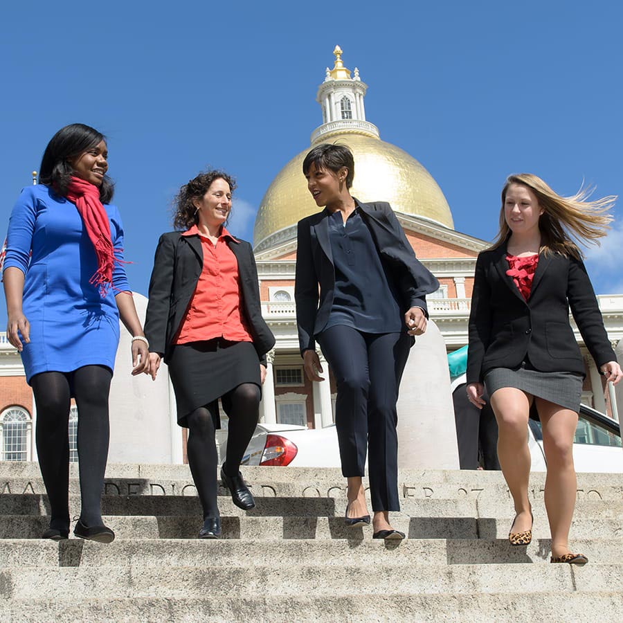 women reviewing document in front of state house building