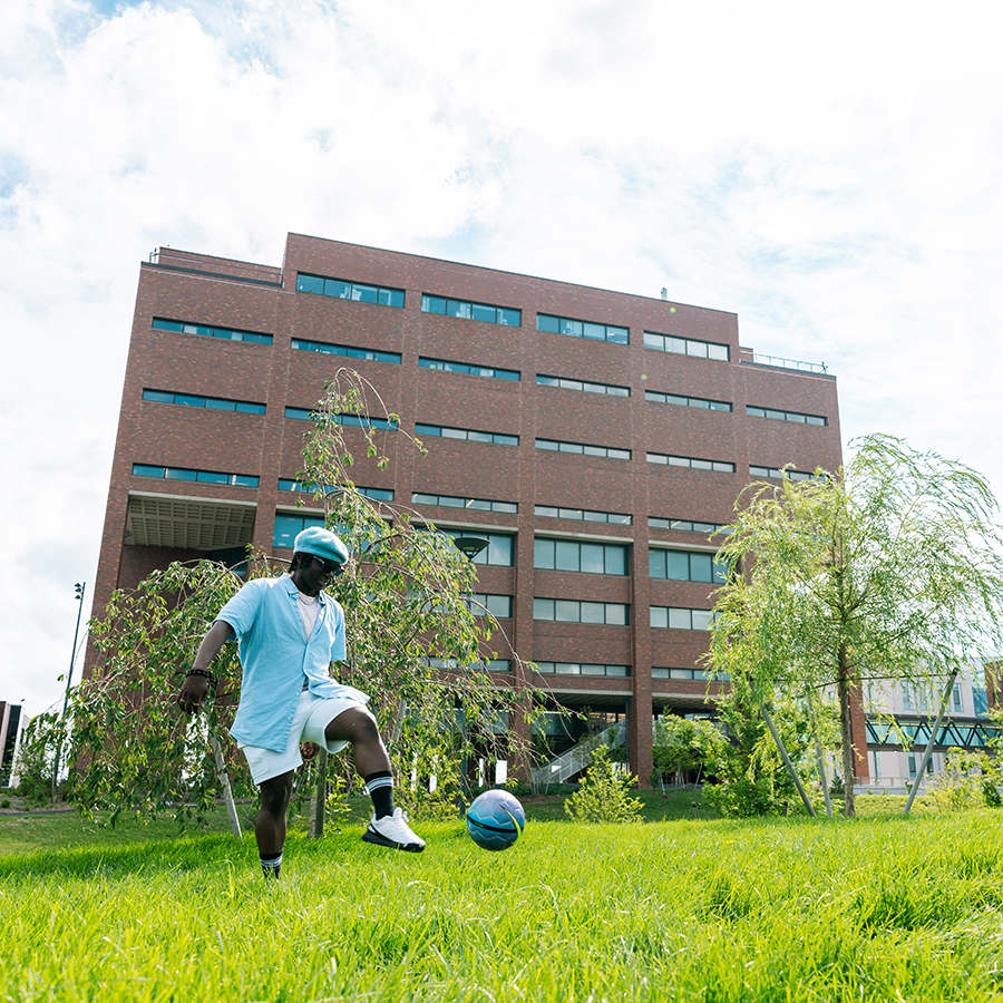 quad student plays with ball on campus green quad