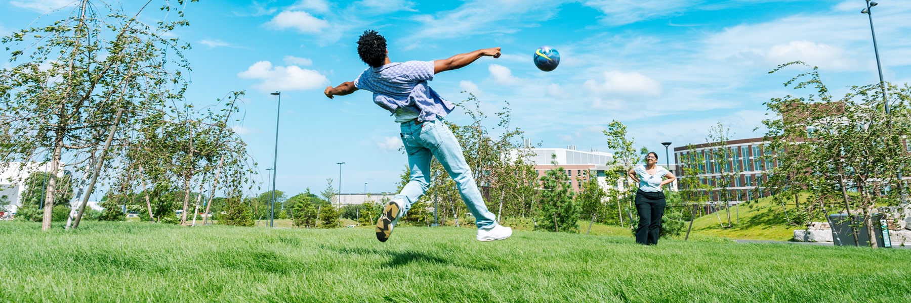 student plays with soccer ball on quad