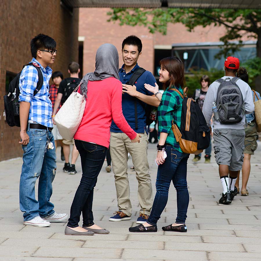 diverse students talking on plaza