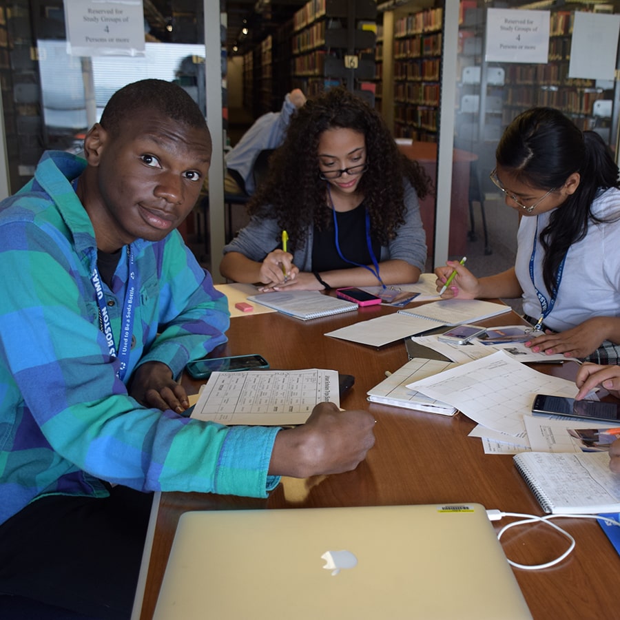 students working at table in room with clear walls