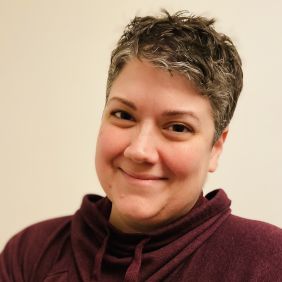 Woman with short grey hair and red sweater