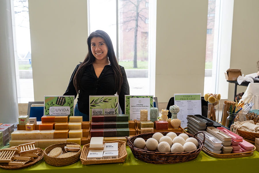Maria Vasco, the founder of Uvida Shop, stands behind her table at the 2026 Earth Day Activities Fair