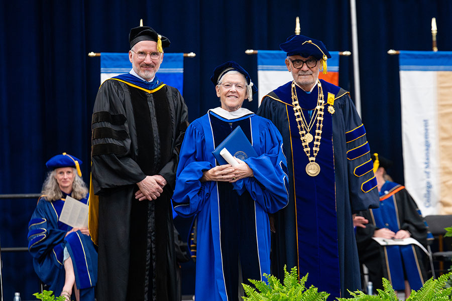 McCarthy stands with the Provost and Chancellor after receiving her honorary degree at the 2026 Doctoral Hooding Ceremony